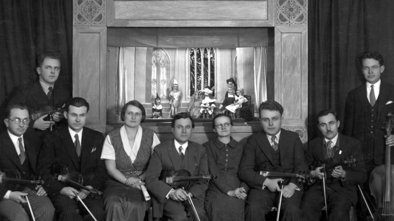 Fotografija iz foto-albuma češke besede Daruvar – u prvom planu muzički sastav, iza lutkarsko kazalište. Lutka „Kašpárek“ posve lijevo. (Arhiv Saveza Čeha)